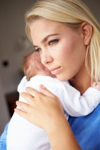 Depressed Mother Cuddling Newborn Baby