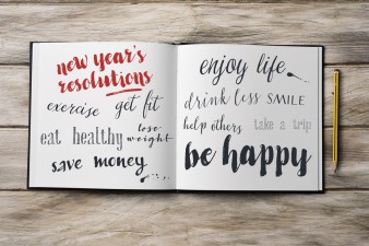high-angle shot of a pencil and a notebook with some new years resolutions written in it, such as exercise, get fit, eat healthy, save money, smile, enjoy life or be happy, on a rustic wooden surface